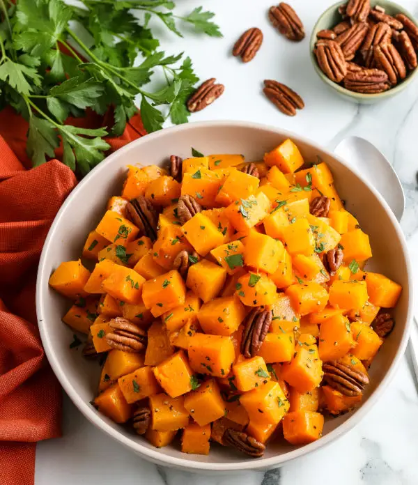 Flat lay of roasted butternut squash cubes on a baking sheet, golden brown and perfectly caramelized for a healthy side dish.