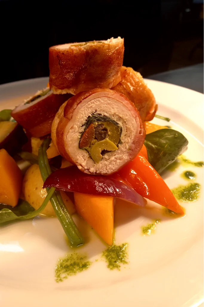 Stuffed chicken breast sliced over vegetables