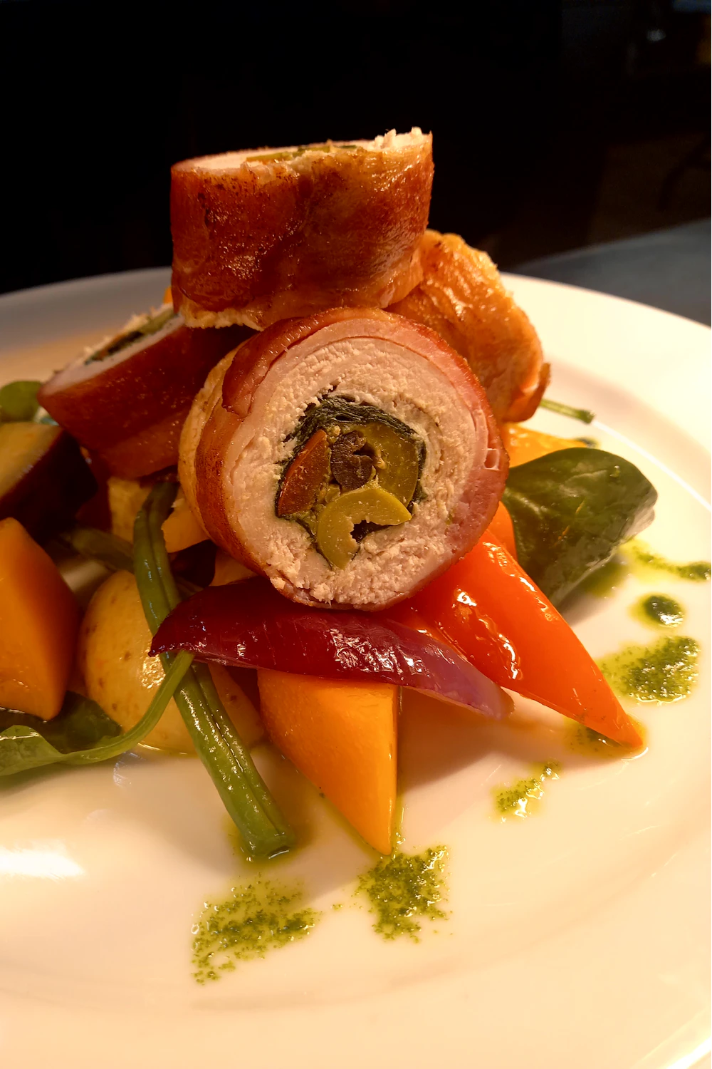 Stuffed chicken breast sliced over vegetables