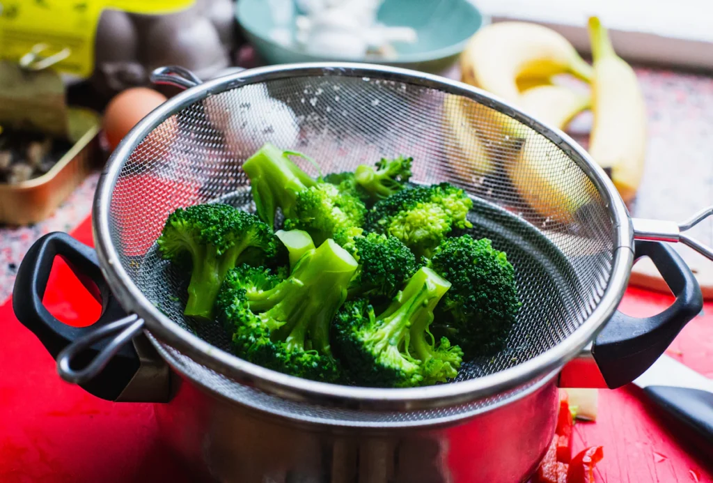 Blanched broccoli florets in a colander
