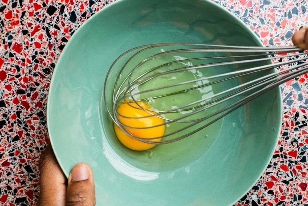Smooth egg mixture being whisked in a bowl