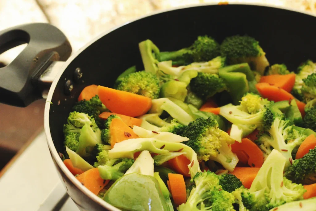 Broccoli and carrots stir frying in a wok