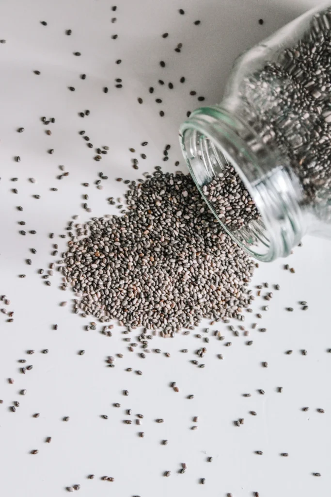 Chia seeds spilling from a glass jar, the base of chia pudding