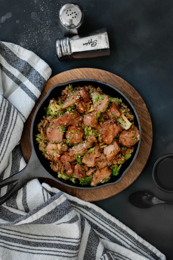 Chicken pieces browning in a cast iron skillet