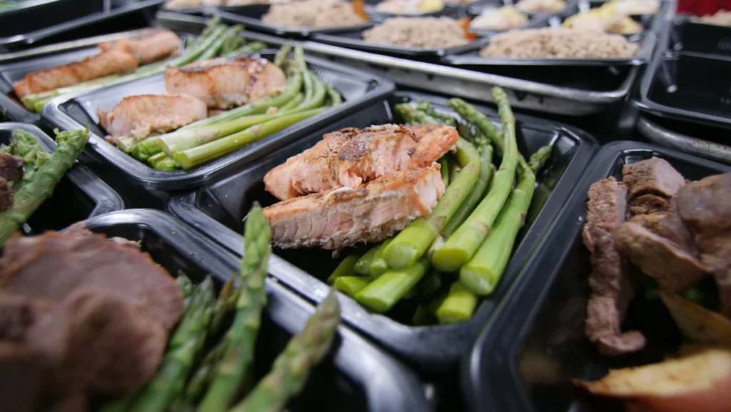 Meal prep containers filled with chicken and green vegetables for the week