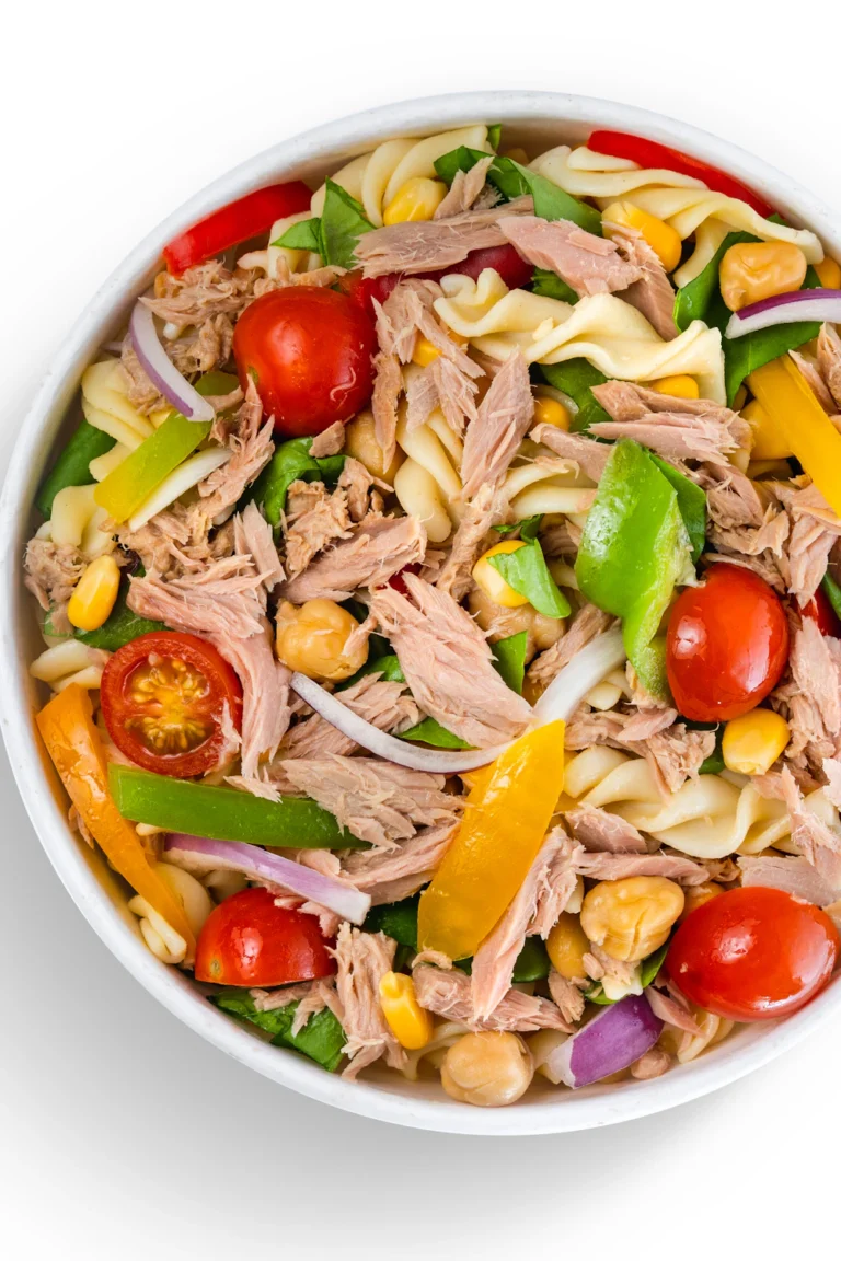 Chicken pasta salad with rotini, tomatoes, cucumber and Italian dressing in a white bowl