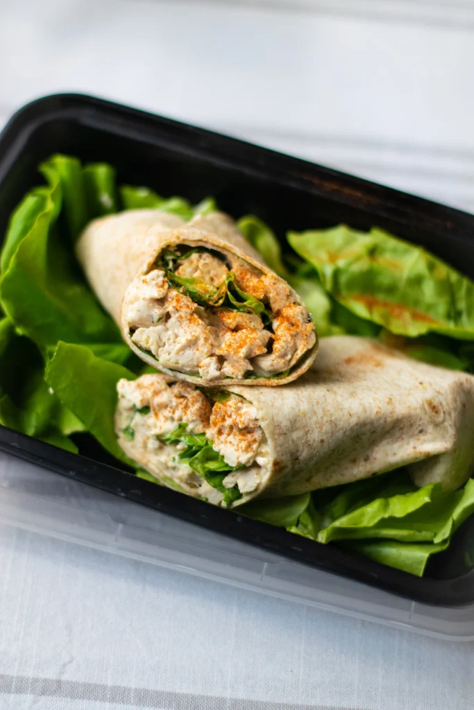 Chicken salad wraps sliced in half on a plate