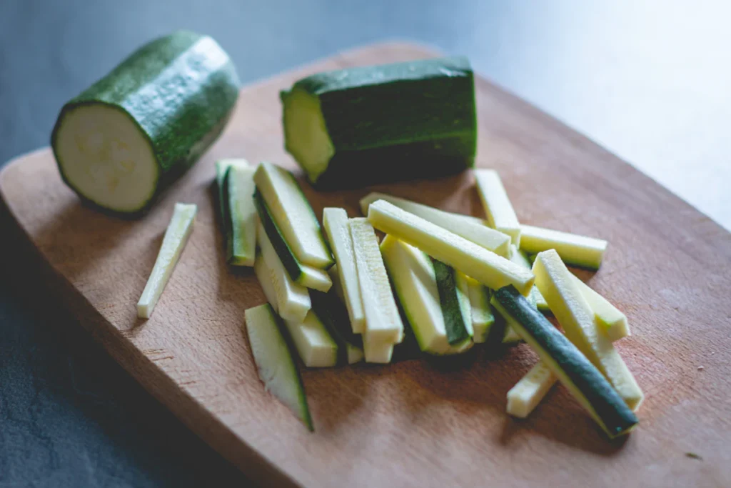 Fresh zucchini sliced on a wooden cutting board