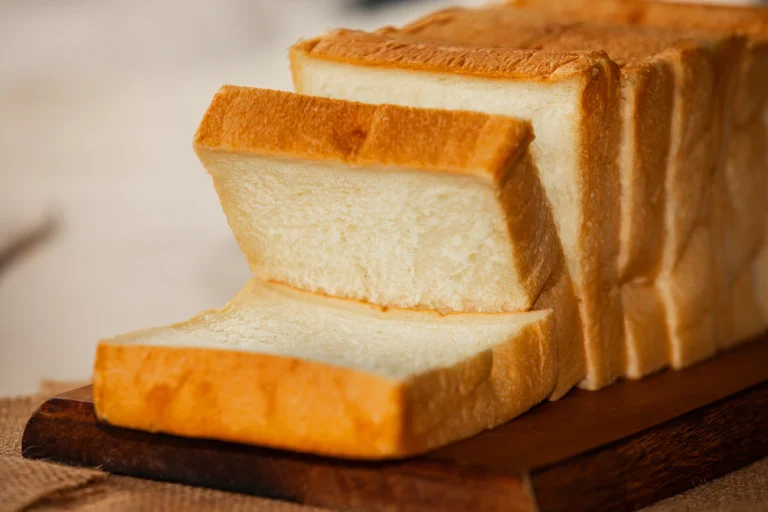 Sliced soft cottage cheese protein bread loaf on a wooden board