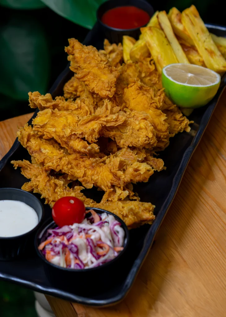 Crunchy breaded chicken strips piled on a board