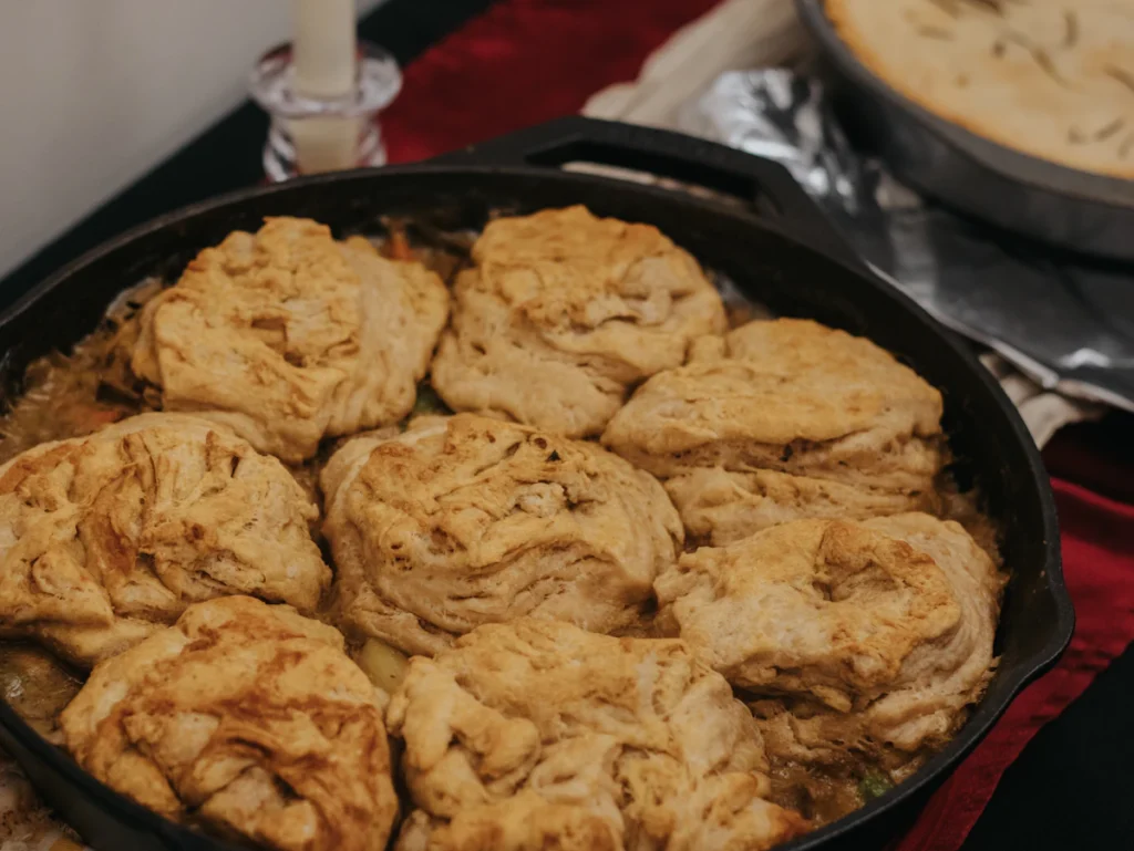 Golden fluffy drop dumplings in a cast iron skillet