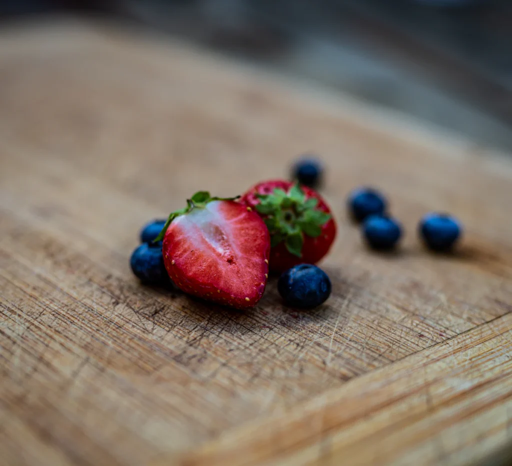 Fresh strawberries and blueberries on a wooden board