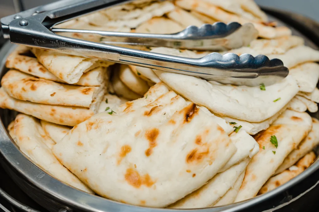 Soft golden flatbreads with browned spots stacked in a pan