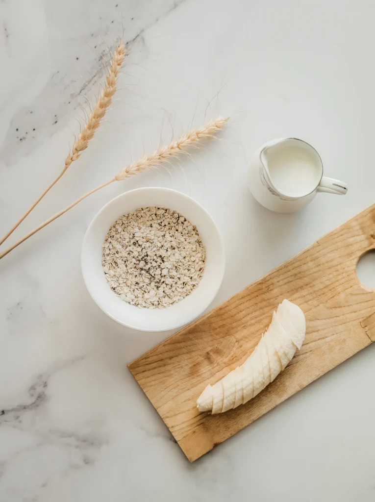 Baked oats ingredients: rolled oats, ripe bananas, and milk on a table