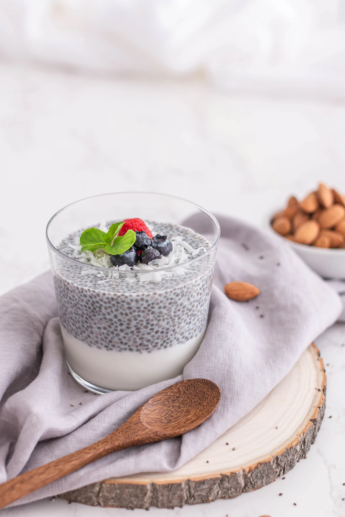 High protein chia pudding in a glass topped with berries and almonds