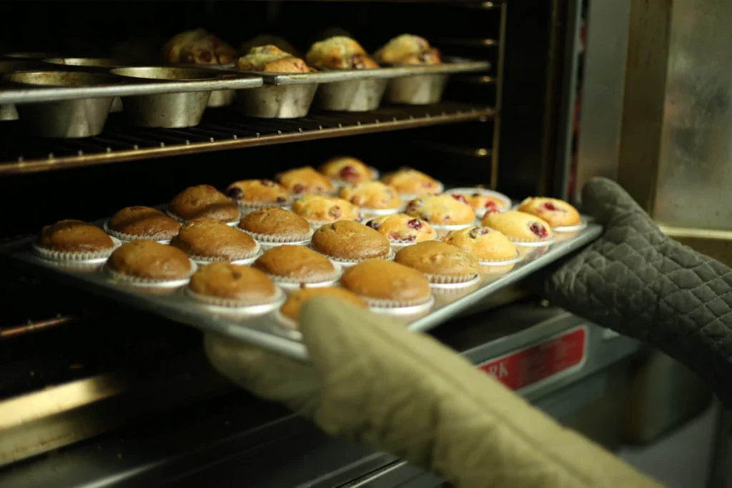 Muffins rising in the oven on a baking tray