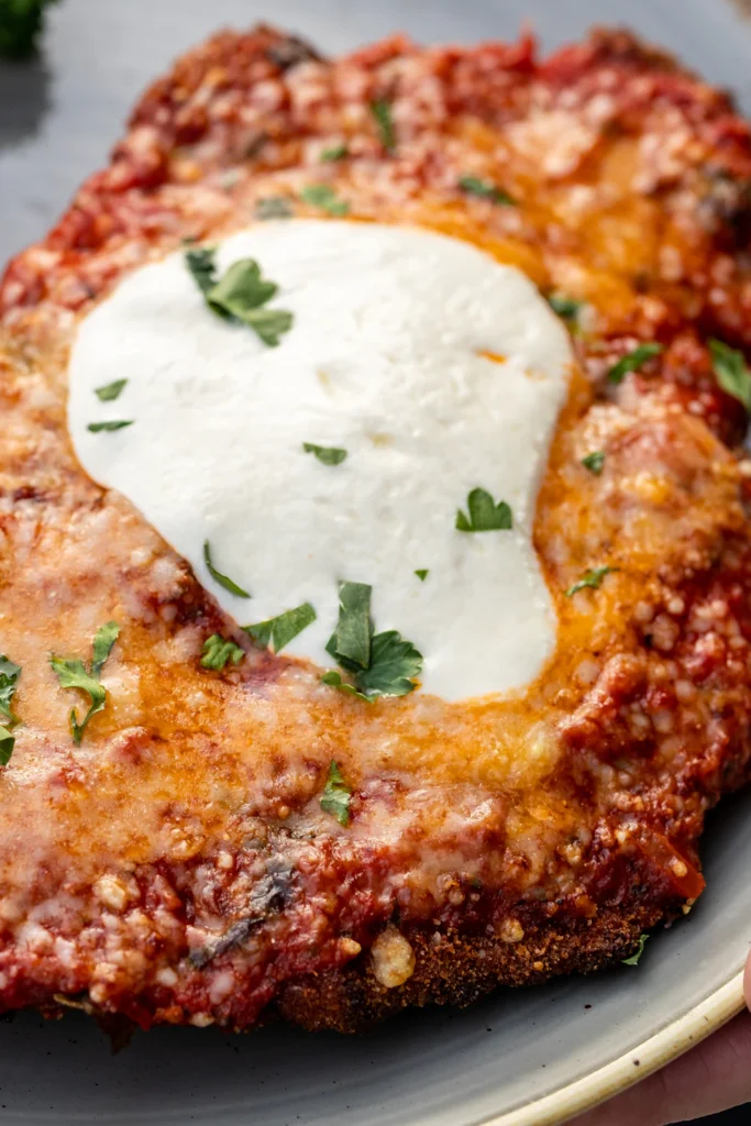 Crispy Parmesan chicken cutlet served with greens