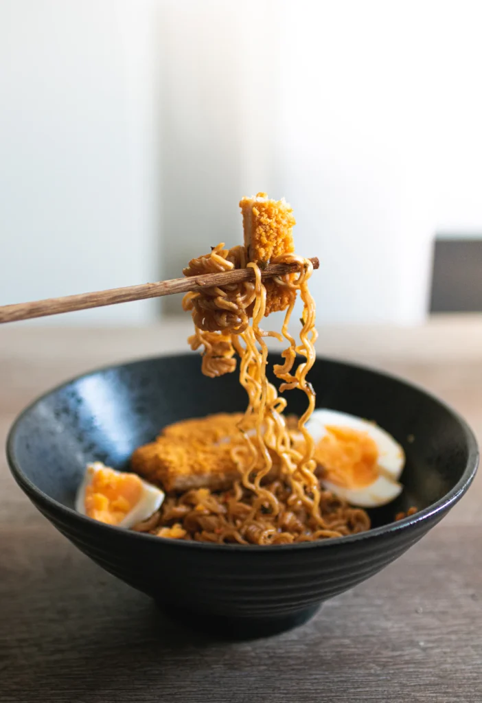 Ramen noodles lifted with chopsticks