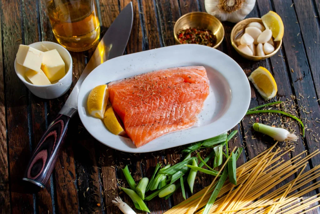 Raw salmon fillet with lemon, garlic, herbs, and spices for air fryer salmon bites