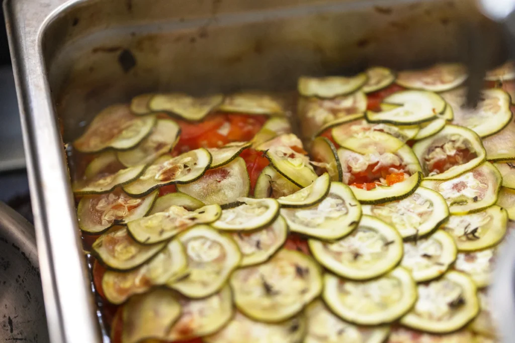 Sliced summer squash arranged in a baking pan