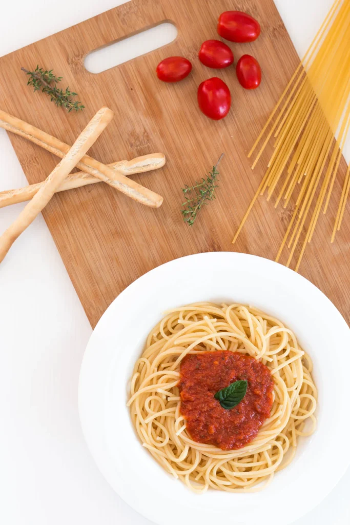 Bowl of spaghetti with tomato meat sauce and fresh tomatoes