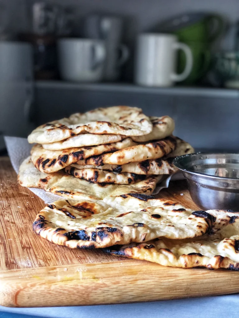 Stack of flatbreads on a wooden board ready for storing or reheating