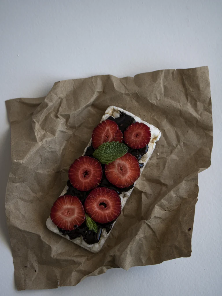 Pieces of frozen yogurt bark with strawberries on parchment