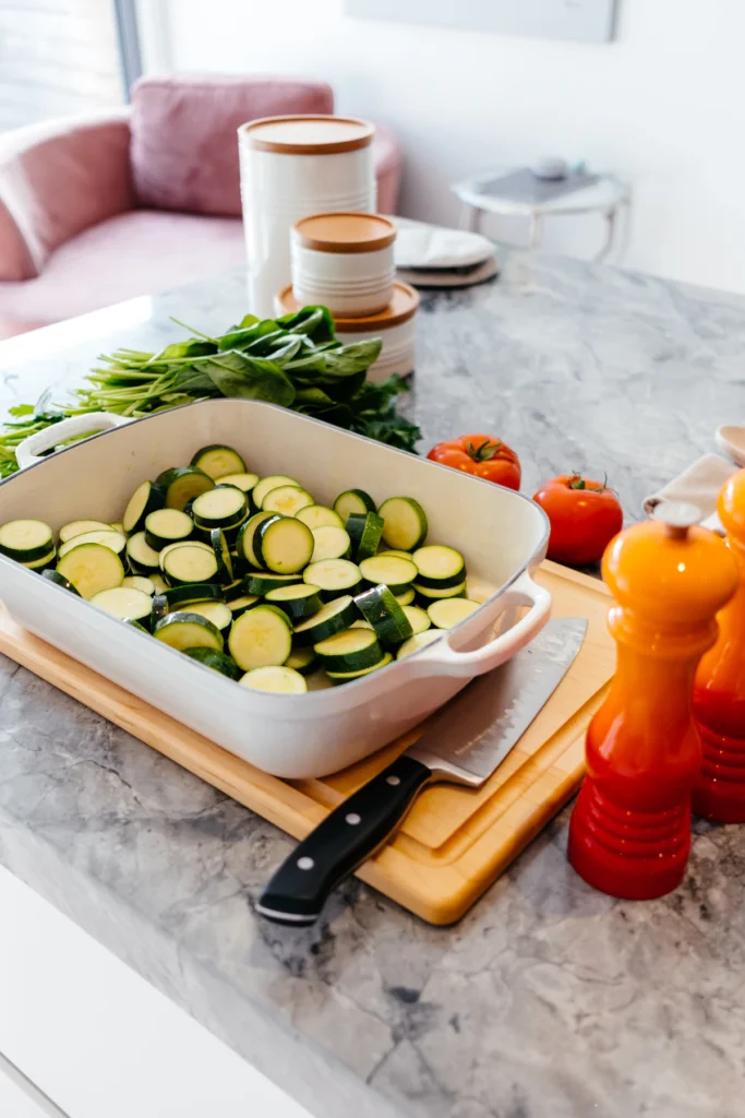Sliced zucchini layered in a white baking dish