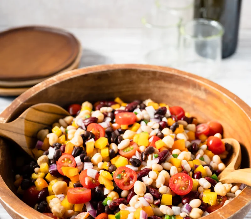 Bowl of black bean quinoa salad with corn, peppers, and fresh herbs
