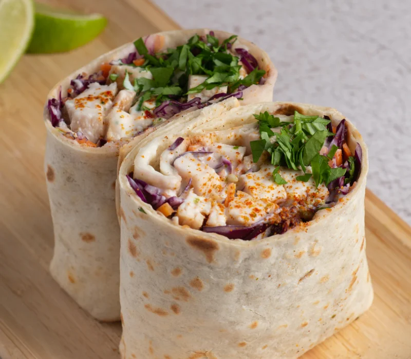 High protein flatbread wraps filled with chicken, cabbage, and fresh herbs