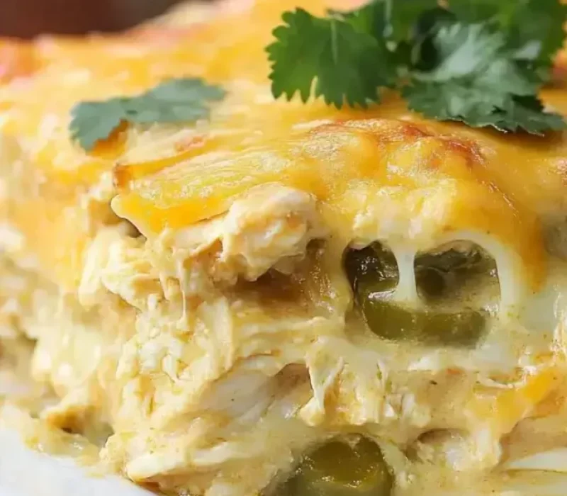 Green chile chicken enchilada casserole with melted Monterey Jack in a baking dish